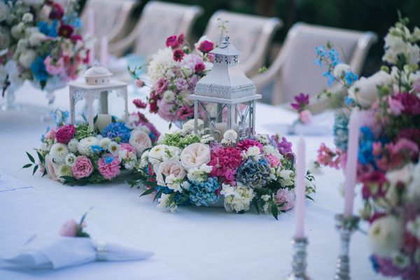 عروسی میز عروسی که با دکوراسیون گل و شمع تزئین شده است