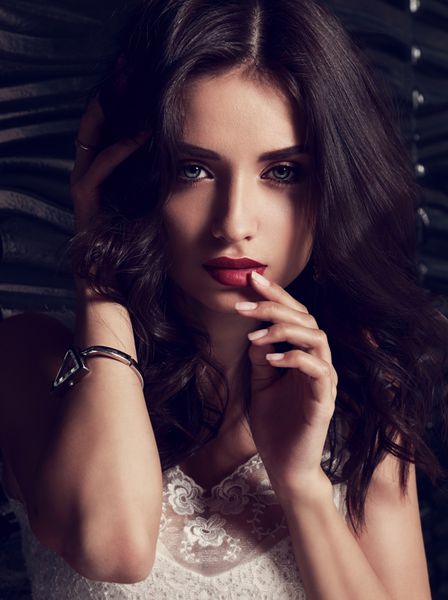 مدل آرایش زن با موهای فرفری بلند قرمز تیره لمس لب انگشت های ظریف او آراسته صدای زیر closeup مد پرتره