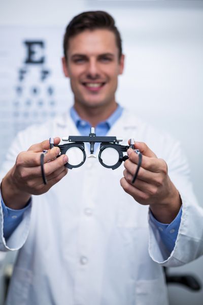 پرتره عینک ساز خندان نگه داشتن messbrille در کلینیک چشم پزشکی