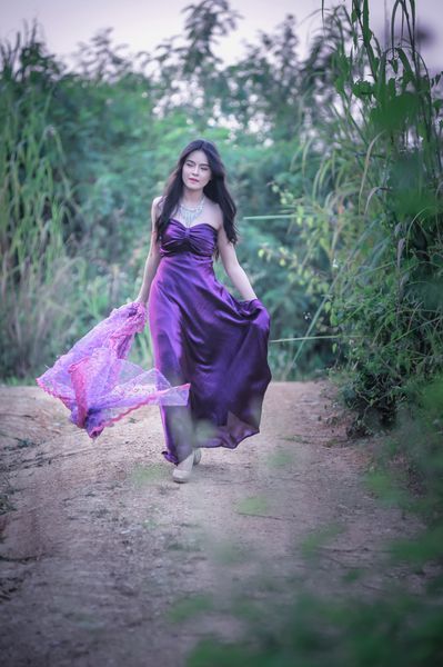 آسیا دختر زیبا راه رفتن در طبیعت در لباس بنفش