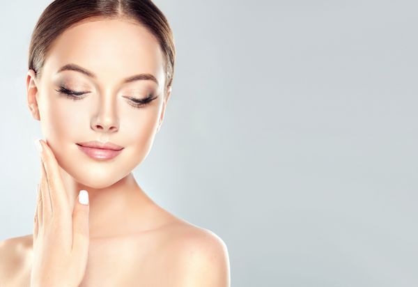 زن جوان زیبا با پوست تازه پاک می کند لمس صورت خود را درمان صورت لوازم آرایشی و بهداشتی زیبایی و آبگرم