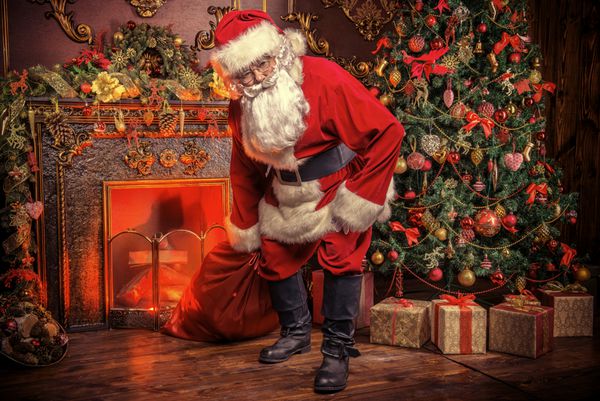 بابا نوئل کیسه را با هدیه برای کریسمس آورد خانه زیبایی برای کریسمس تزئین شده است