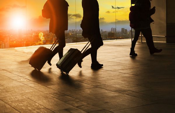 مردم و مسافرت چمدان در ساختمان ترمینال فرودگاه با آسمان خورشید آسمان در صحنه های شهری و هواپیما پرواز پرواز پس زمینه