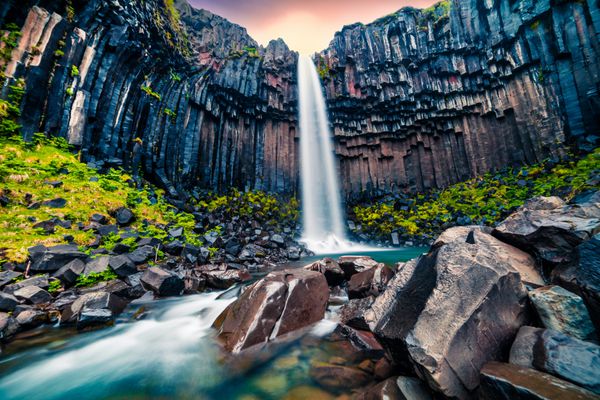 نمایش صبح دراماتیک از آبشار معروف Svartifoss Black Fall طلوع تابستان رنگارنگ در Skaftafell پارک ملی Vatnajokull ایسلند اروپا سبک هنری پست عکس پردازش شده
