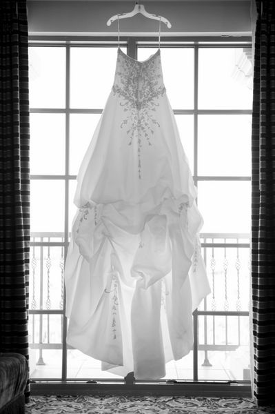 لباس عروسی که در یک پنجره آویزان است