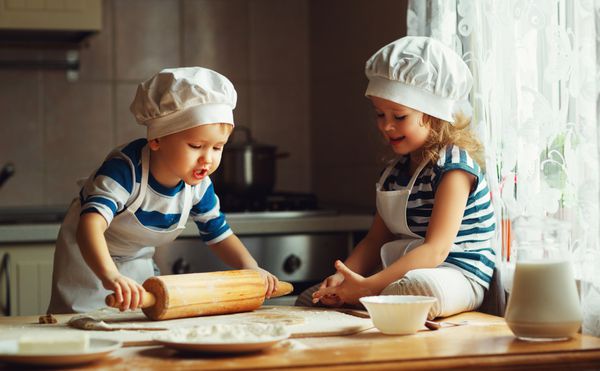 بچه های شاد خانواده خنده دار در حال تهیه خمیر هستند کوکی ها را در آشپزخانه بپزید