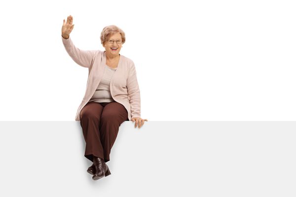 زن سالخورده شاد بر روی یک پنل نشسته و بر روی زمینه سفید انفرادی گذاشته است