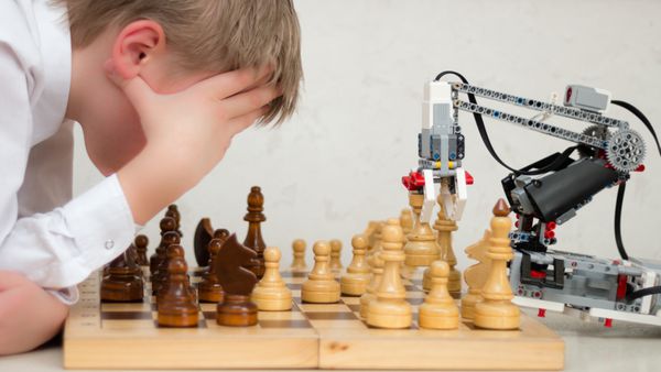 بازوی ربات بازی شطرنج با نوجوان مفهوم آموزش STEM یادگیری الکترونیکی