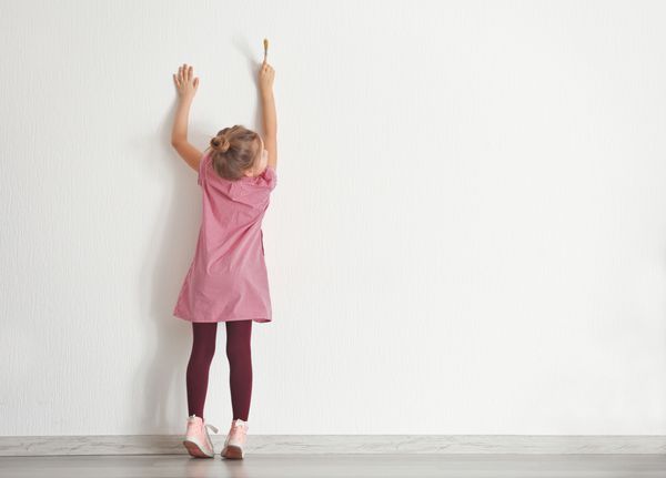 نقاشی ناز کوچک دختر در دیوار در اتاق خالی