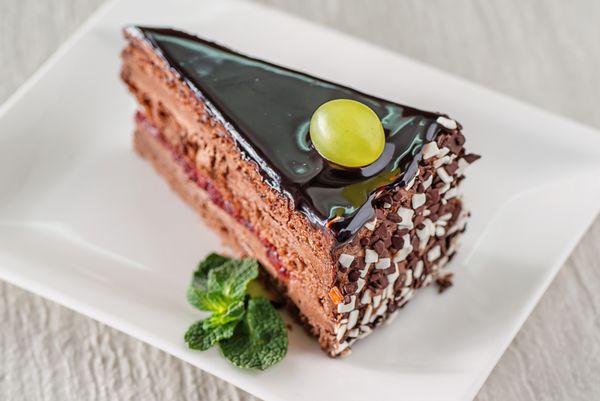 کیک شکلاتی کیک شکلاتی با شکلات تیره و انگور تازه در بالا عکاسی محصول برای patisserie