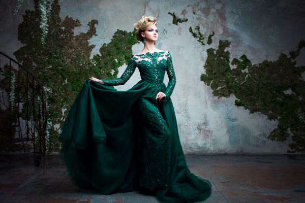 پرتره زن جوان جذاب در لباس سبز زیبا پس زمینه بافت داخلی مدل موهای لوکس