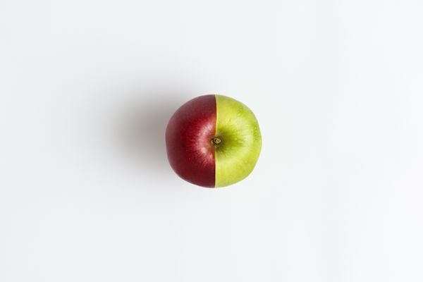 دیدگاه بالای یک سیب که از دو نیم قرمز و سبز جدا شده است