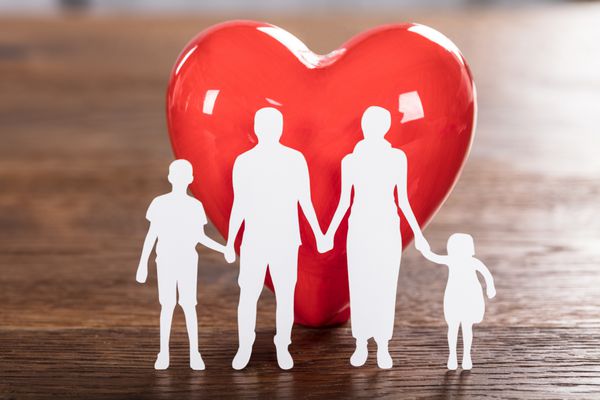 نزدیک به یک مفهوم بهداشت خانواده با خانواده قطع و قلب قرمز در میز چوبی