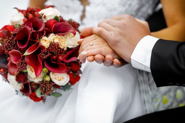 دست های جدید از عروسی با حلقه های عروسی و عروسی عروسی تازه وارد با حلقه های عروسی و دسته گل عروسی