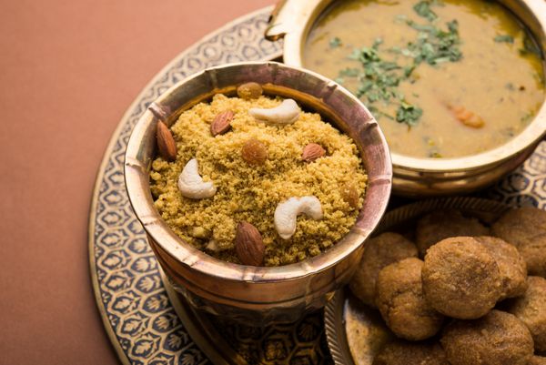 دال باتی کرما یک غذای سالم است که از هند راجستان خدمت بر روی ورق برنجی و کاسه در پس زمینه مودمی