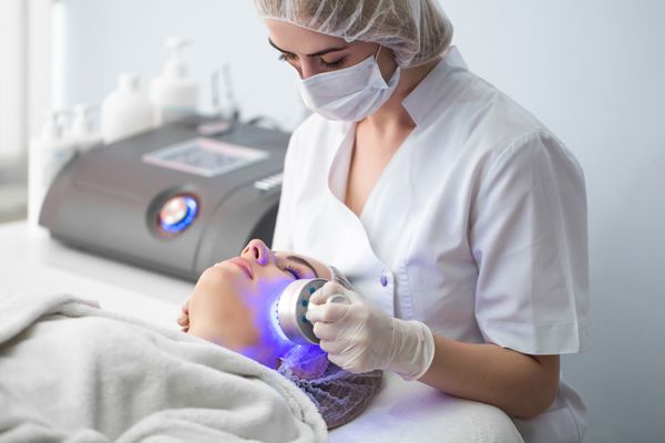 ماساژور اولتراسونیک درمان پوست نور زن در سالن زیبایی