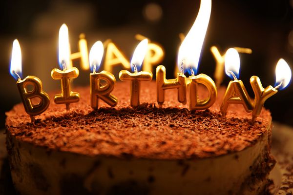 شمع تولدت مبارک با آتش بر روی یک کیک