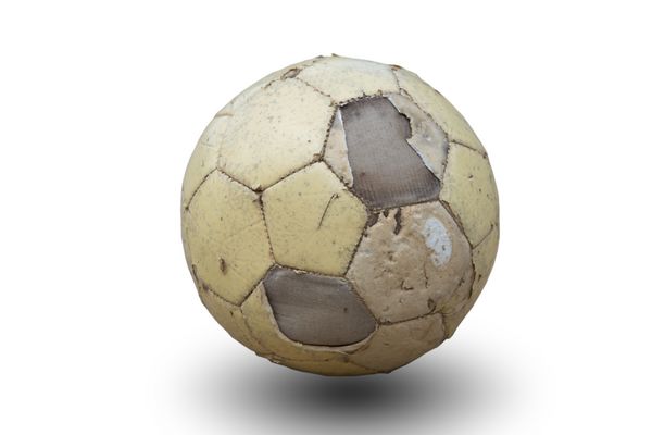 توپ فوتبال قدیمی جدا شده بر روی زمینه سفید