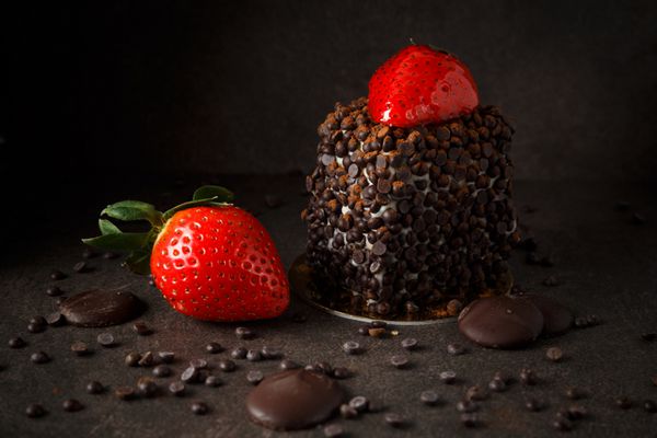 قطعه کیک شکلاتی با توت تازه در زمینه تاریک
