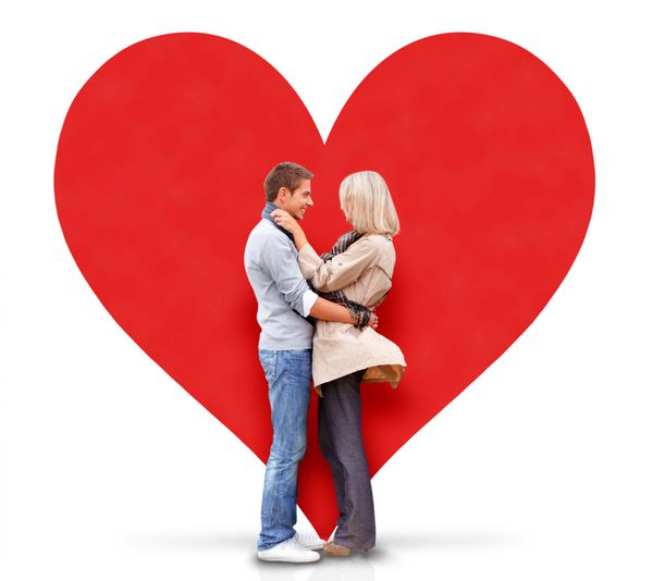 زن و شوهر جوان در آغوش گرفتن یک قلب قرمز بزرگ پشت سر آنها وجود دارد جدا شده بر روی زمینه سفید