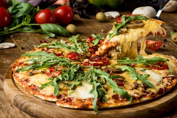 نزدیک پیتزا ایتالیایی قطعه قطعه شده با آرژول تازه