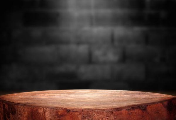 جدول چوب قدیمی با دیوار بلوک بلوط تیره در پس زمینه اتاق تاریک