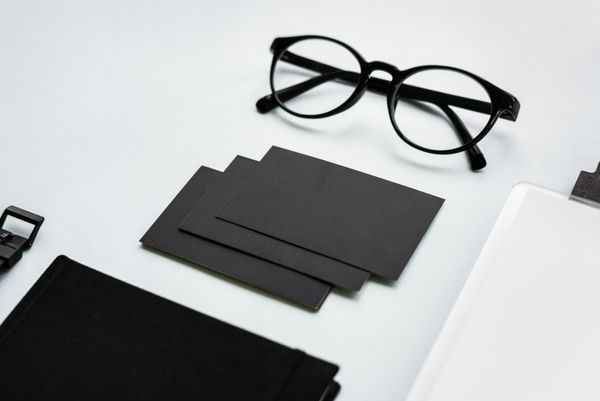 نزدیک کارت های کاغذی سیاه و سفید با عینک بر روی میز