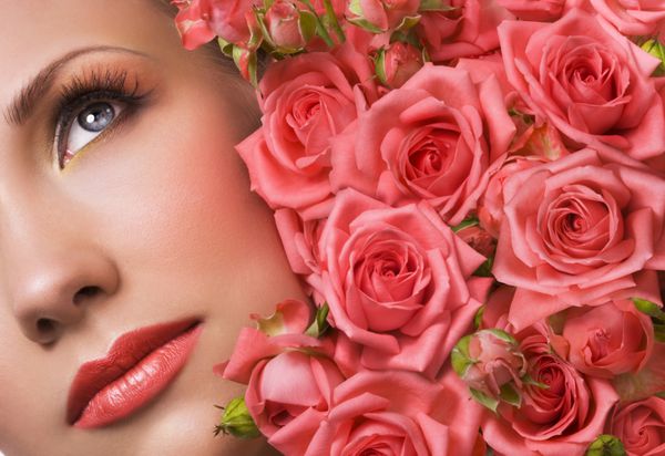 زن با آرایش زیبا و دسته گل رز مرجانی