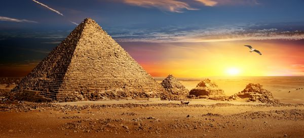 اهرام مصر در بیابان ماسه و آسمان روشن است