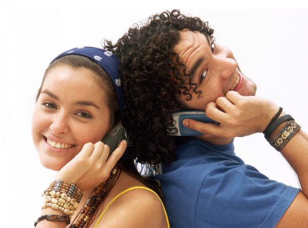 زن و شوهر جوان با استفاده از یک تلفن همراه زن و شوهر جوان با تلفن همراه خود صحبت می کنند