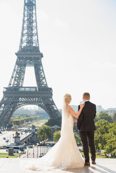 زن و شوهر در لباس عروسی در مقابل برج ایفل در پاریس