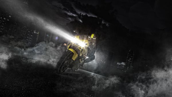 سوارکار موتور سوار سوارکار در شب رانندگی می کند آسمان خراش های مدرن در پس زمینه اثر دود در اطراف عکاسی تصویر زمینه سرعت مسافرت و آزادی