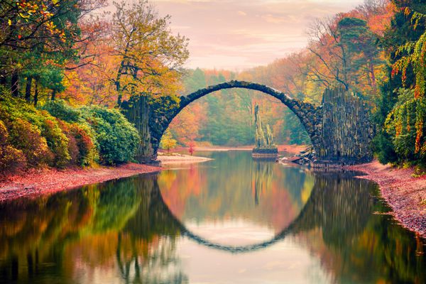 Impressive sunset in Azalea and Rhododendron Park Kromlau Germany Europe Picturesque autumn view of Rakotz Bridge Rakotzbrucke Devil