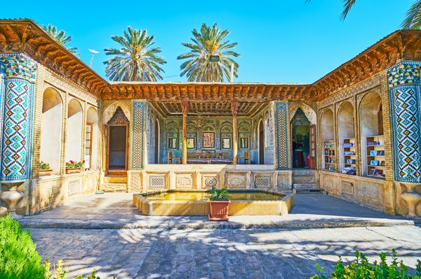 شیراز ایران 12 اکتبر 2017 پانوراما از عمارت آینه عمارت Zinat Ol-Molk با آینه های پیچیده ستون های بلند و باریک از چوب حک شده تزیینات سنگ و الگوهای کاشی در روز 12 اکتبر در شیراز