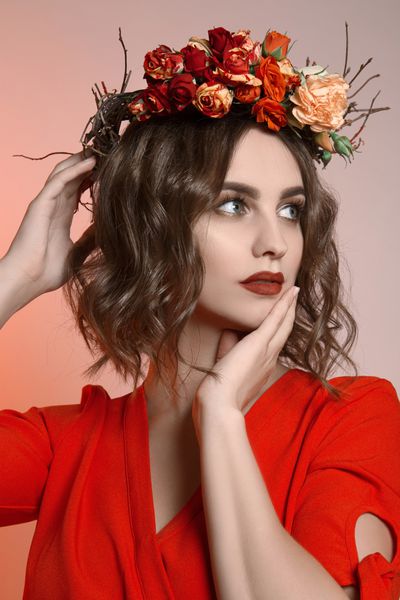 دختر زیبا با موهای زبر و گل در آنها عروسی افسانه ای از زن جوان با لباس و لباس قرمز نماد تابستانی