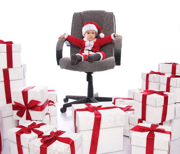 پسر بچه در لباس بابا نوئل نشسته در دفتر صندلی