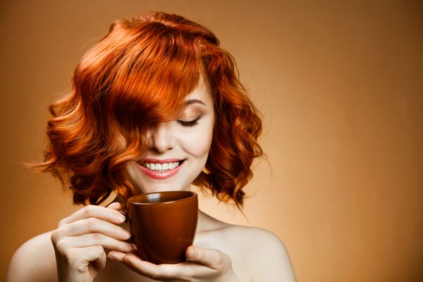 زن شیک با یک قهوه معطر در دست