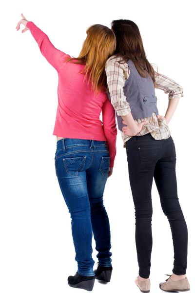 نمای عقب دو زن جوان سبزه و بلوند که به دیوار نشان می دهند مجموعه افراد با نمای عقب نمای پشت فرد دوستان دختر زیبا نشان دادن با زمینه سفید مجزا شده است