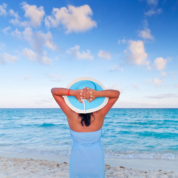 زن در کلاه استراحت در تعطیلات در دریای کارائیب