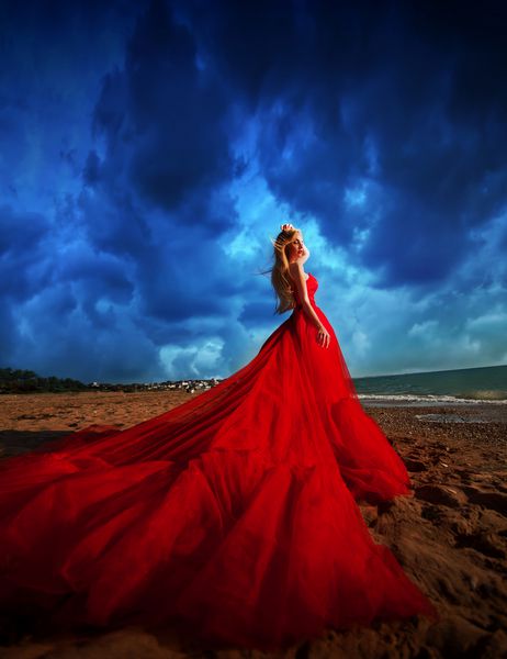 زنی با لباس قرمز در ساحل تعطیلات دریایی سفر به دریا