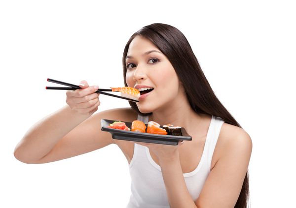 زن زیبا در حال خوردن سوشی با الیاف شیشه ای جدا شده