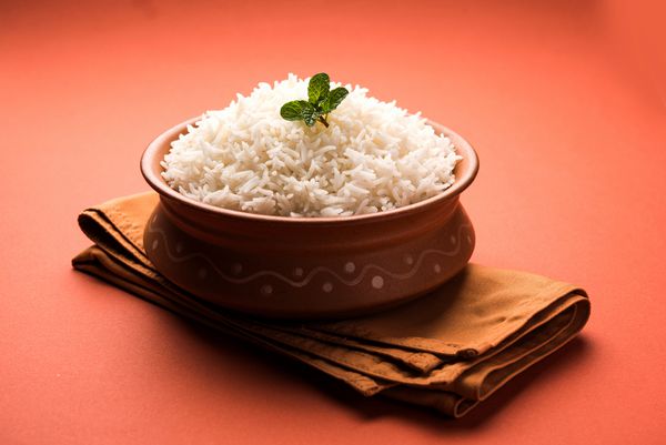 برنج باسماتی سفید ساده و پخته شده را در کاسه ای مایل به زرد یا با چوب چوبی مخلوط کنید