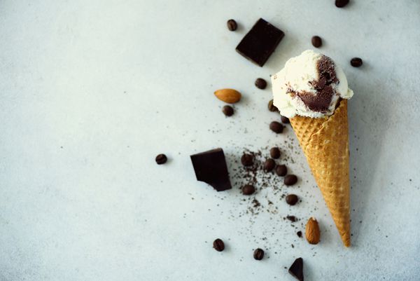 بستنی شکلات وانیل و قهوه در مخروط وافل با لوبیا قهوه در زمینه سنگ خاکستری مفهوم غذای تابستانی فضای کپی بستنی سالم بدون گلوتن