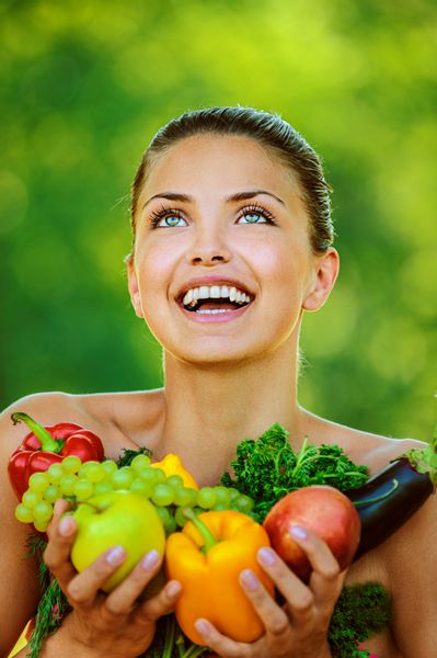 پرتره زن زیبا و جوان با شانه های که دارای میوه و سبزیجات است فلفل سیب بادمجان جعفری انگور با طبیعت تابستانی با زمینه سبز