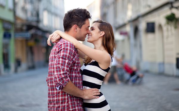 زن و شوهر جوان عاشق در خیابان در آغوش گرفته اند تمرکز انتخابی
