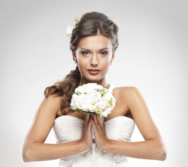 عروس جذاب جوان با دسته گلهای رز سفید
