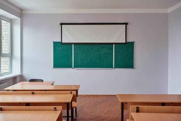 فضای داخلی کلاس در مدرسه با تخته سیاه میز و صندلی