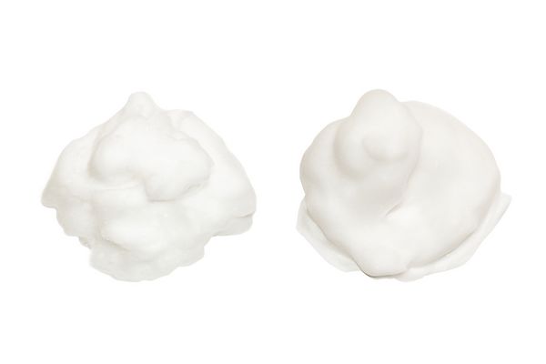 کرم صابون فوم جدا شده بر روی زمینه سفید فوم نرم سفید بافت حباب حمام کرم اصلاح مو