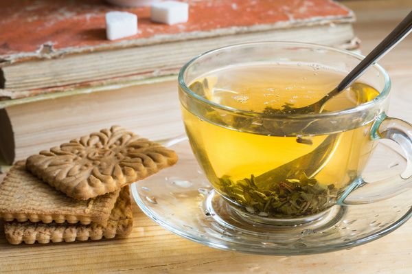چای گیاهی را در یک فنجان شفاف و کوکی ها برای صبحانه میل کنید