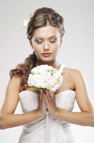 عروس جذاب جوان با دسته گلهای رز سفید
